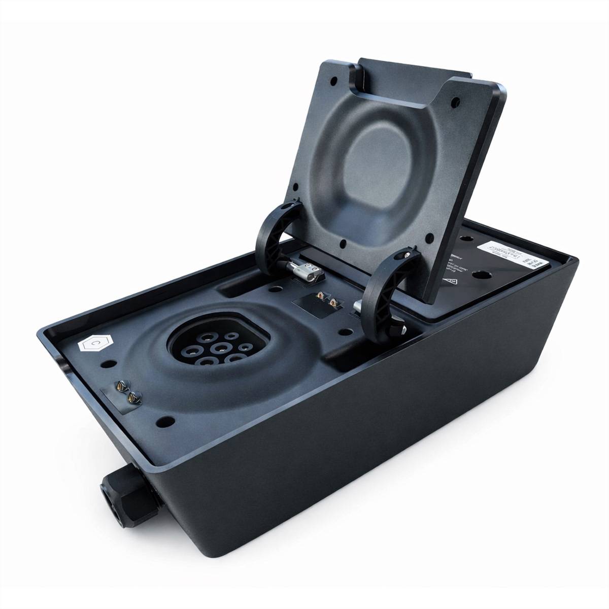 Ein schwarzes elektronisches Gerät mit aufgeklapptem Scharnier, das eine kreisförmige Buchse und Anschlüsse im Inneren zeigt. Es scheint sich um eine Lade- oder Stromstation zu handeln.