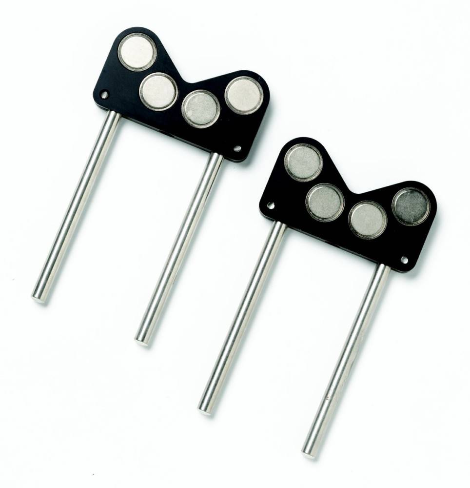 Zwei Metallzungenventile mit angebrachten runden Magneten auf weißem Hintergrund, wahrscheinlich in Motoren verwendet, um den Luftstrom zu regeln.