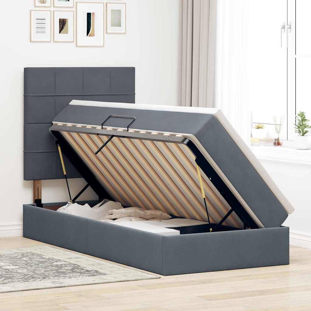 Ein grauß Ottomane-Bett mit hydraulischem Lift zeigt Stauraum unter dem Bett, der Bettwäsche enthält, in einem modernen Schlafzimmer mit gerahmten Kunstwerken und einem Fenster.