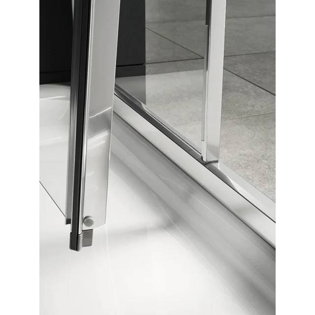 Nahaufnahme einer modernen Glasschiebetür mit Metallrahmen und Schiene auf weißem Boden.