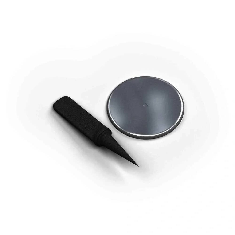 Schwarzer spitzer Marker und runde Magnetscheibe auf weißem Hintergrund.
