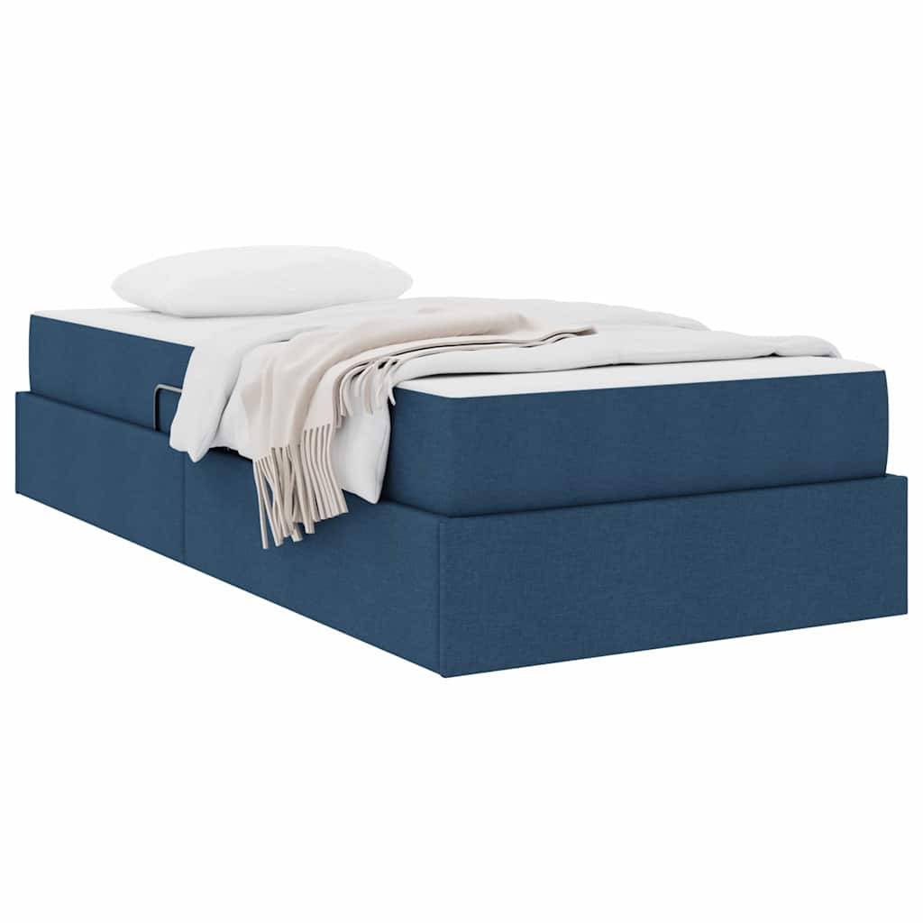 Ein Plattformbett mit blauem Polsterbezug, auf dem ein weißes Kissen und eine beige Decke ordentlich arrangiert sind.