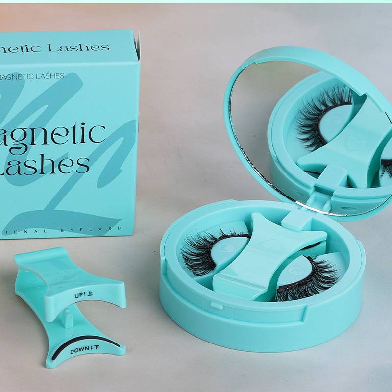 Zwei Sets magnetischer Wimpern in blauen Behältern mit passendem Applikator und Karton mit der Aufschrift 