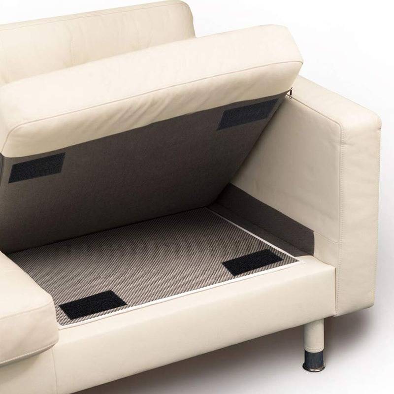 Ein beiges Sofa mit einem offenen Stauraum unter dem Sitzkissen, der ein ausgekleidetes Inneres zeigt, gestützt auf kurze Metallbeine.