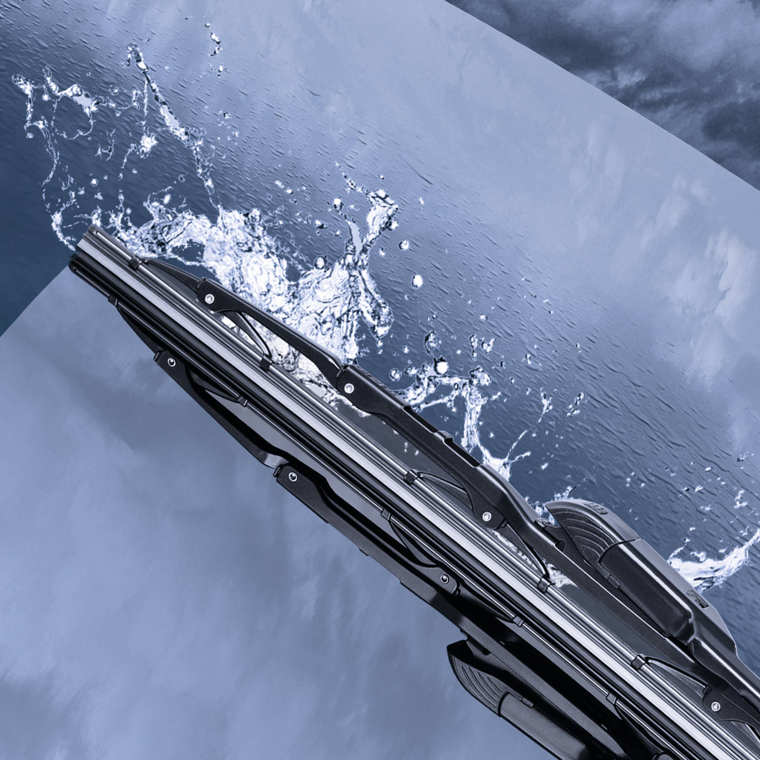 Eine Nahaufnahme eines Scheibenwischers, der Wasser von einer Autoscheibe während eines Regens wischt, mit einem bewölkten Himmel im Hintergrund.