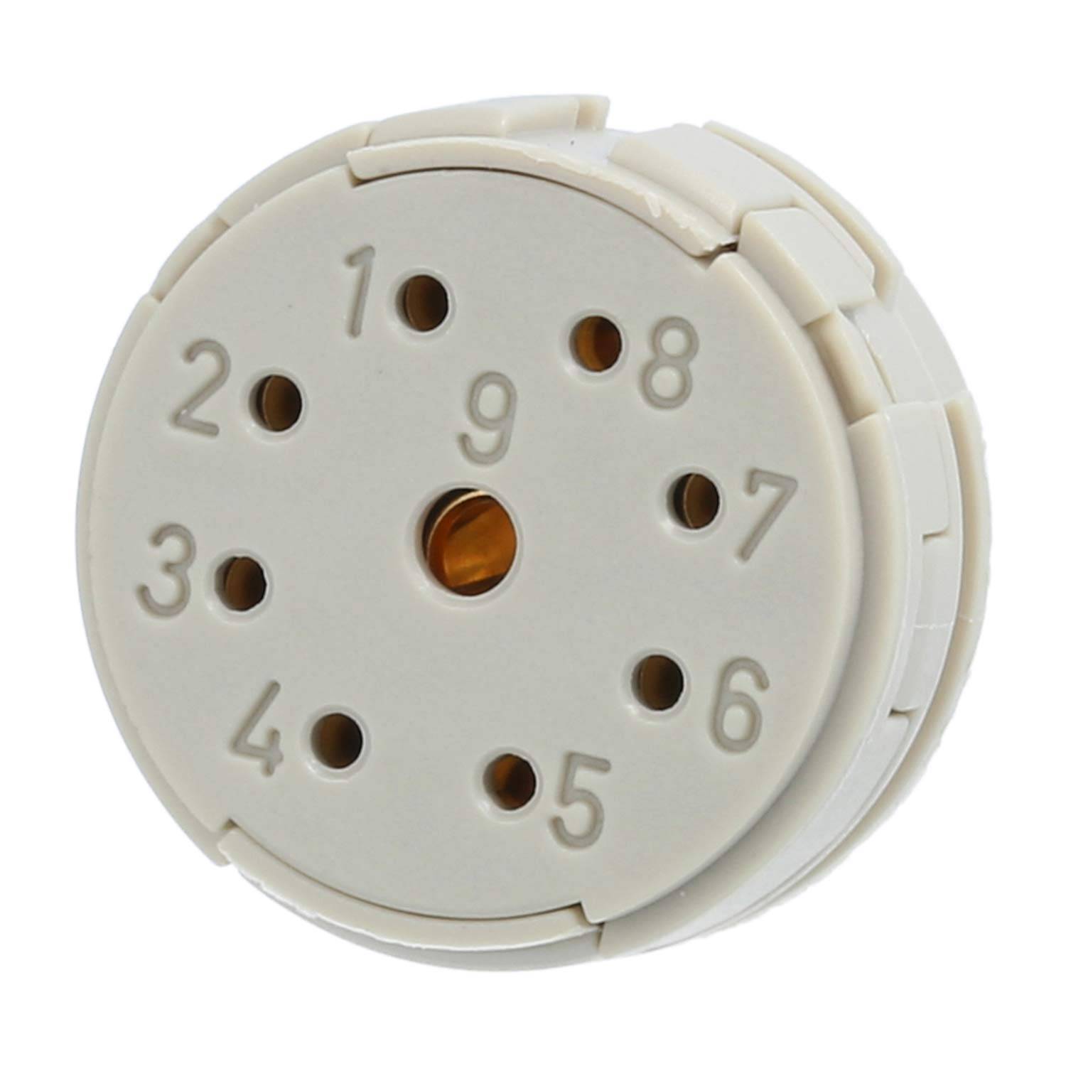 Eine cremefarbene runde Scheibe mit den Zahlen 1 bis 9 und einem zentralen Loch, möglicherweise von einem elektrischen oder mechanischen Gerät.