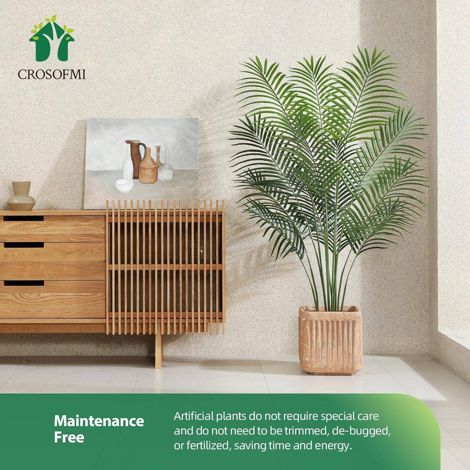 Ein Zimmer zeigt eine Konsole aus hellem Holz und eine große künstliche Topfpalme. Der Text lautet „Wartungsfrei" mit Details zur Einfachheit der Pflanzenpflege.