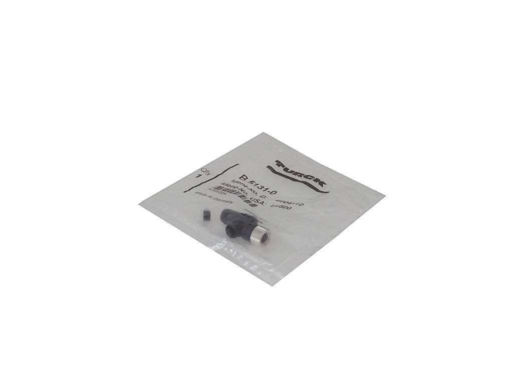 Kleiner elektronischer Stecker oder Adapter in einer beschrifteten Kunststoff-Verkaufstüte auf weißem Hintergrund.