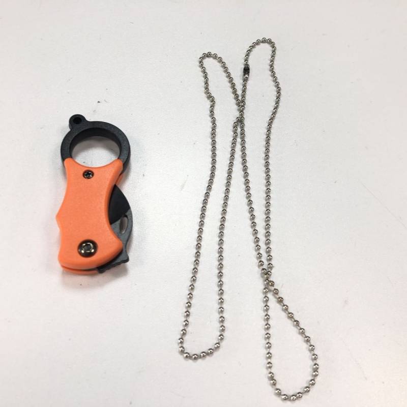 Orange-schwarzer tragbarer Kettenschneider neben einer langen silbernen Kugelkette auf weißem Hintergrund.