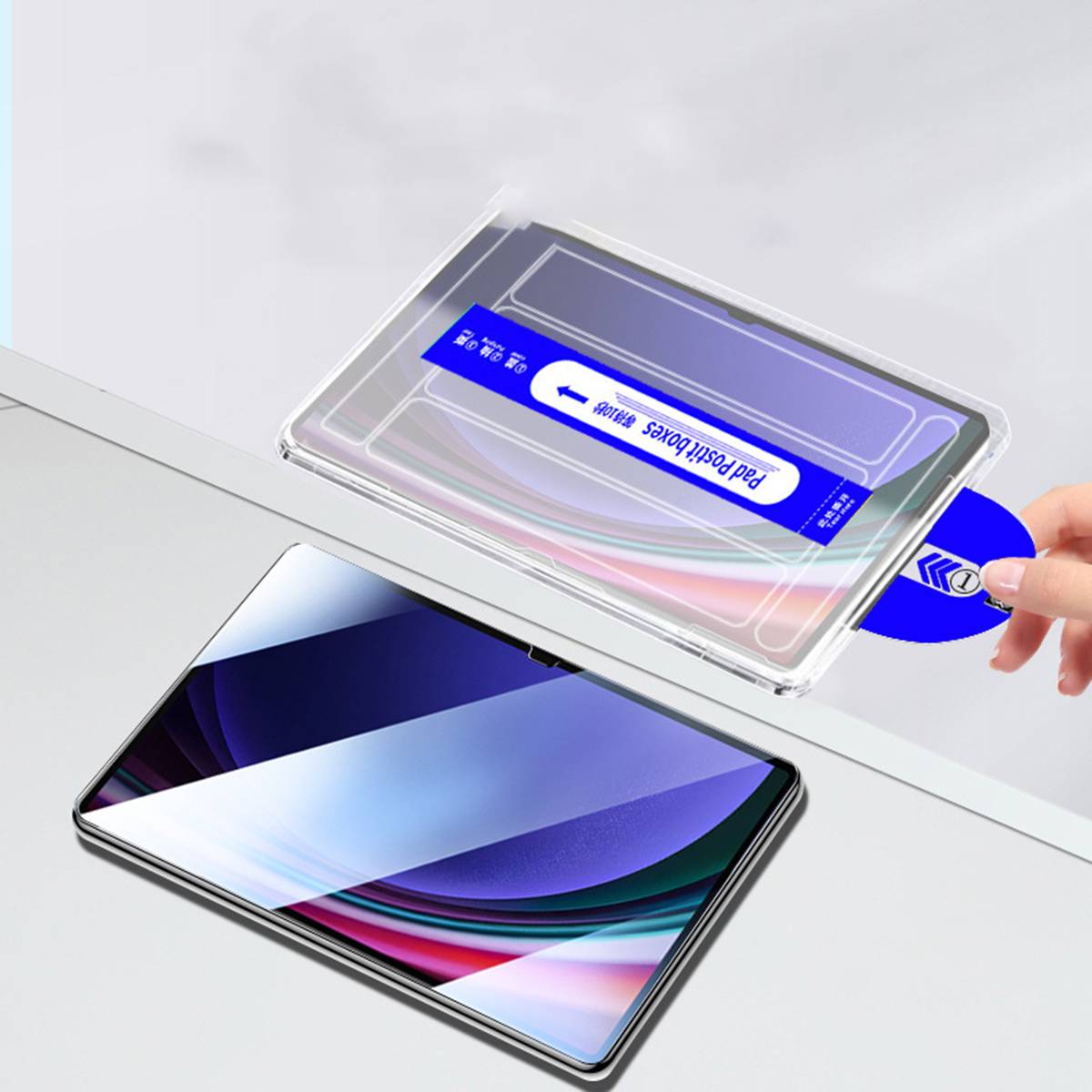 Hände installieren eine klare Schutzfolie über einem Tablet, mit einer blauen Lasche mit der Aufschrift „Pad Protector" auf einem eleganten Gerät darunter.