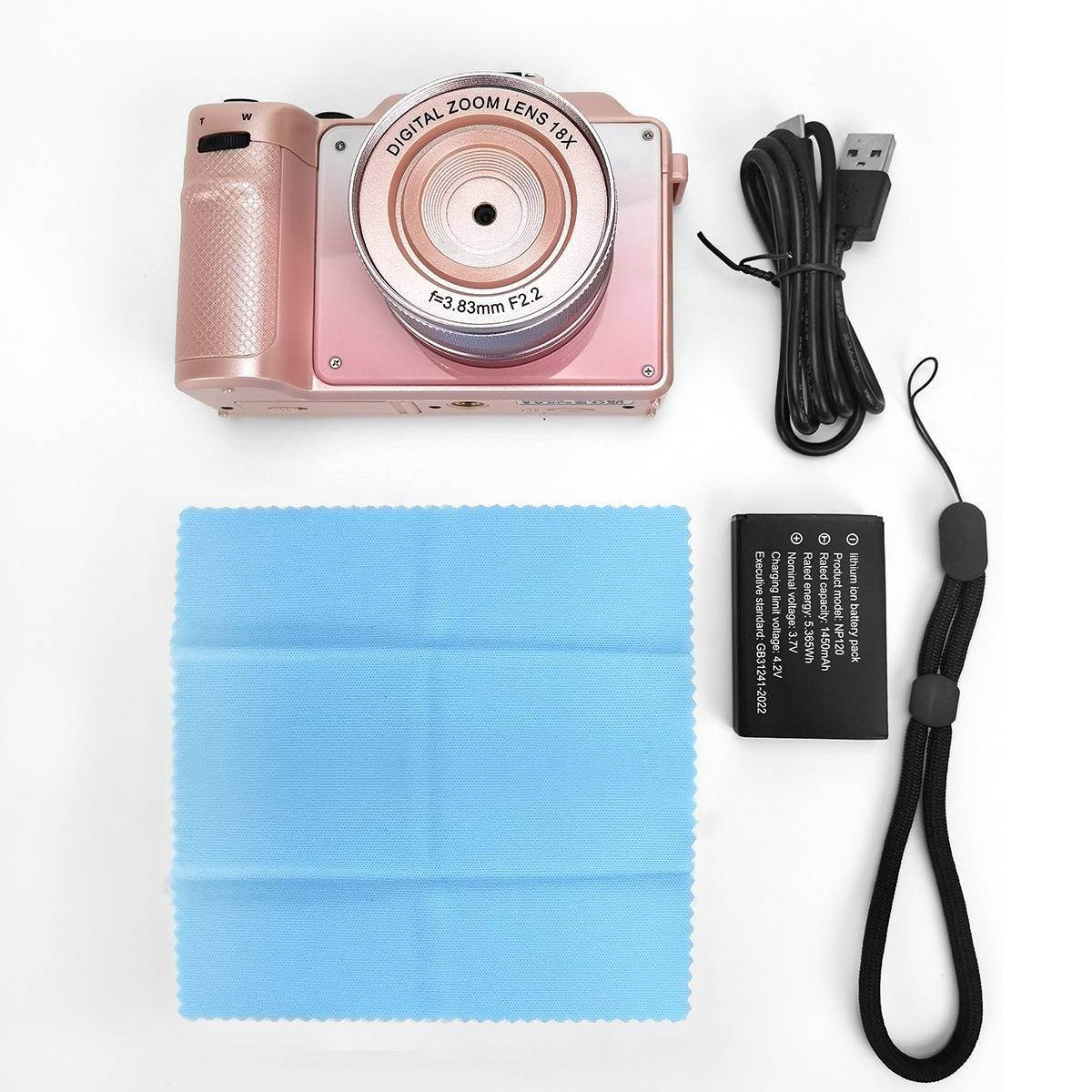 Rosa digitale Kamera mit USB-Kabel, Akku, Handschlaufe und Reinigungstuch auf weißem Hintergrund angeordnet.