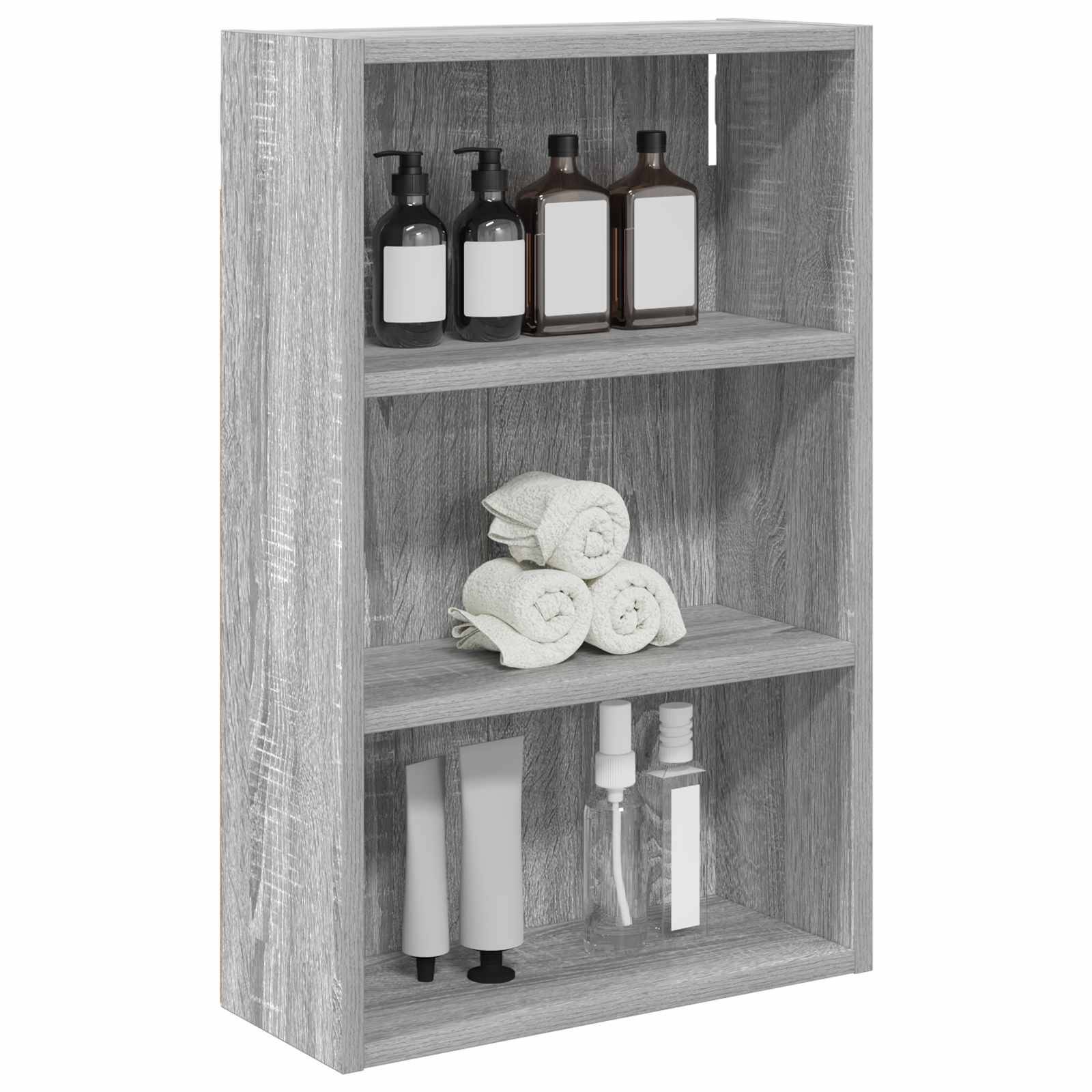 Grauer Holzwandschrank mit drei Regalen, auf dem Badprodukte gelagert werden: Pumpflaschen oben, aufgerollte Handtücher in der Mitte und Tuben sowie Behälter unten.