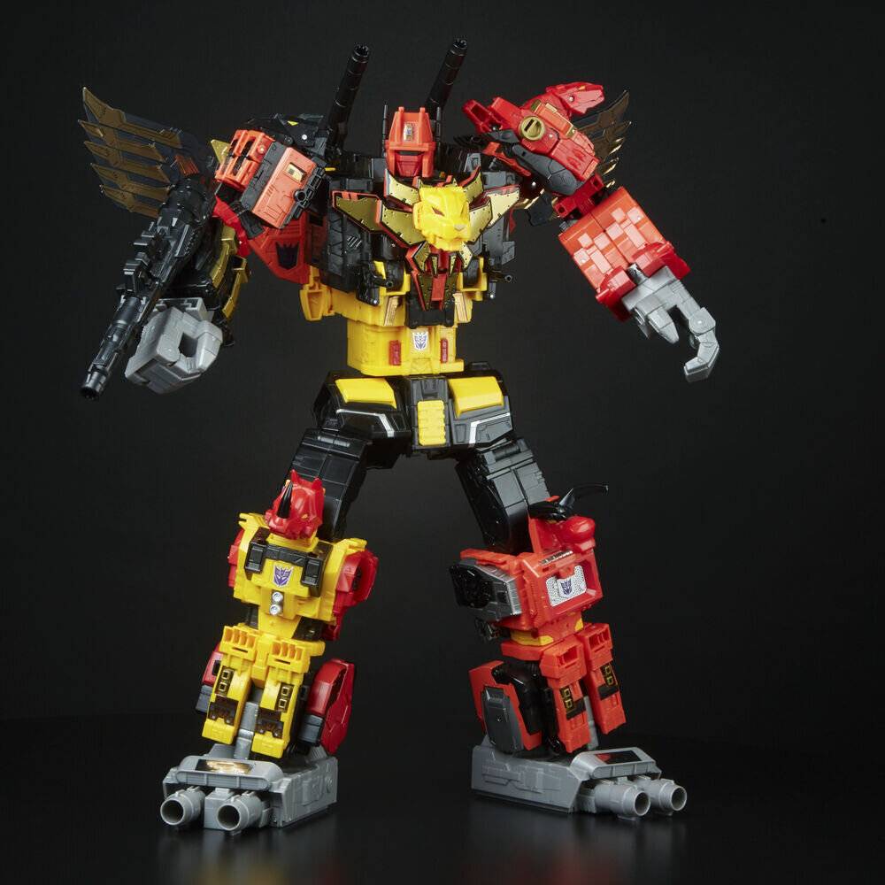 Eine große rot-gelbe Roboterfigur mit Flügeln und aufwendiger Detaillierung steht in Pose und hält eine schwarze Waffe in ihrer linken Hand.