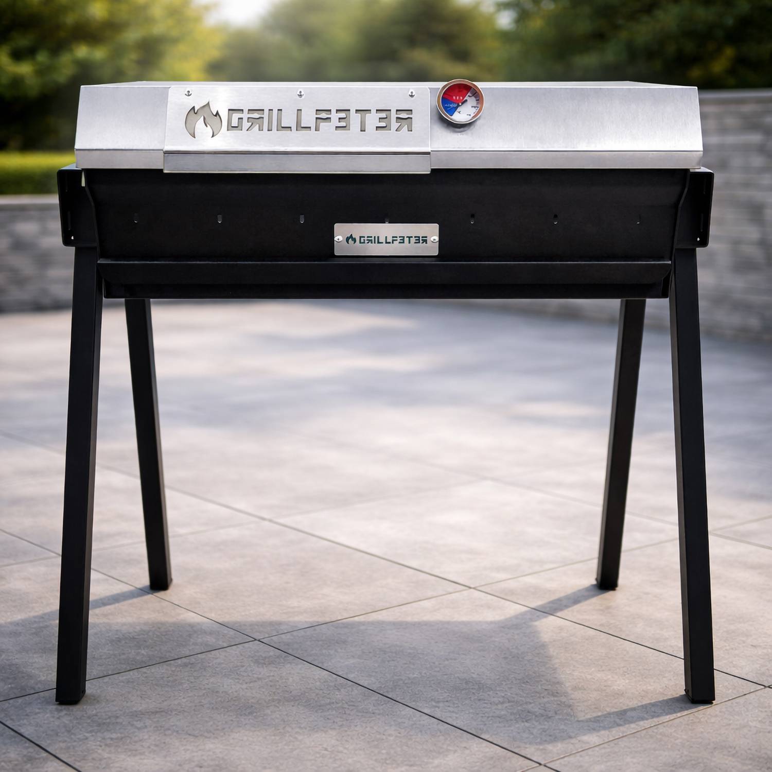 Ein schwarzer und silberner GILLFATER Holzkohlengrill auf vier Beinen, gezeigt im Freien auf einer gepflasterten Terrasse.