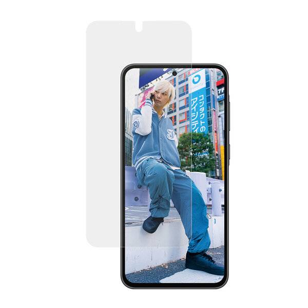 Smartphone zeigt ein Foto einer Person in blauer Kleidung, die draußen vor einem Stadtgebäude mit japanischer Beschilderung posiert.