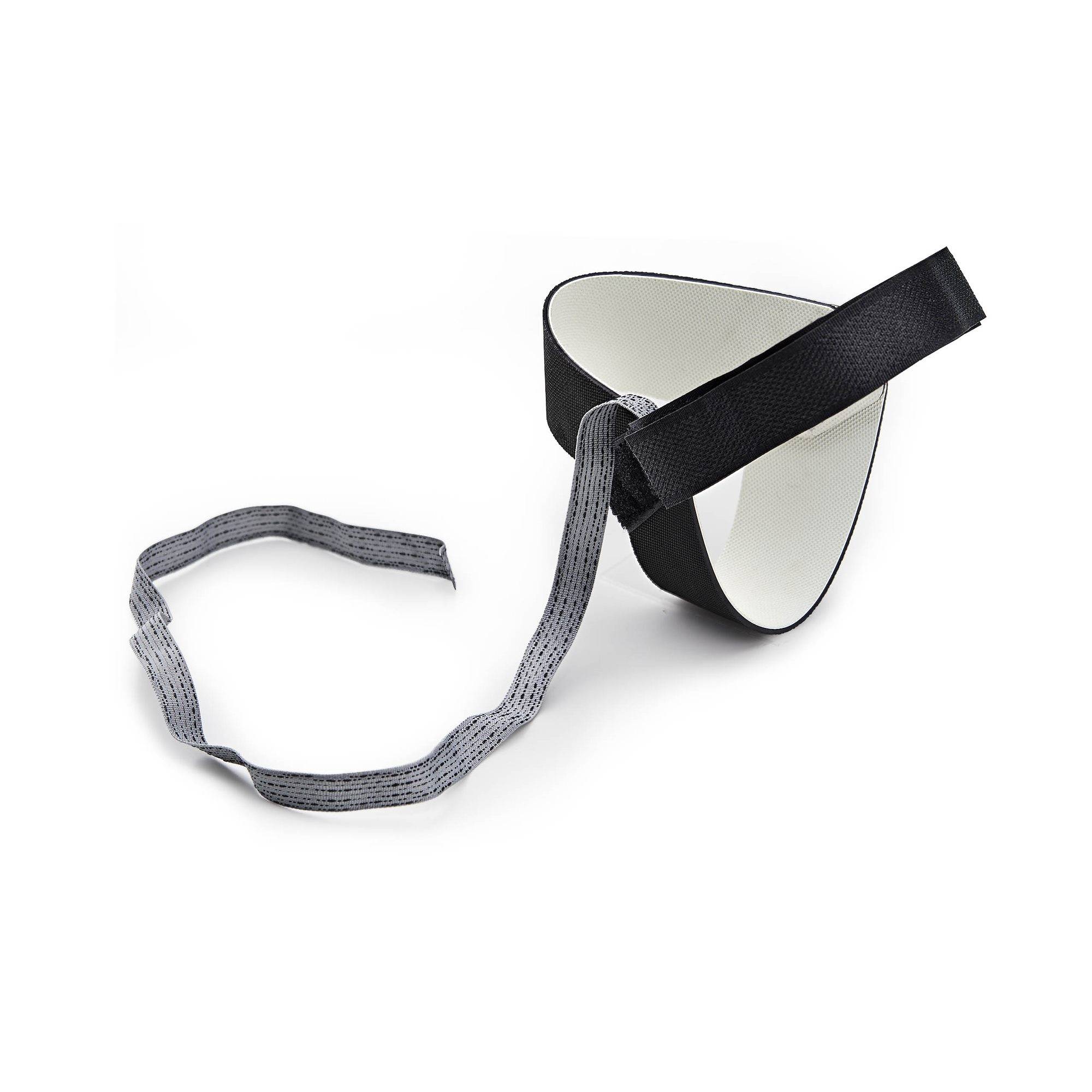 Eine zerbrochene schwarz-weiße Schutzmaske mit einem abgelösten grauen elastischen Gummiband auf weißem Hintergrund.