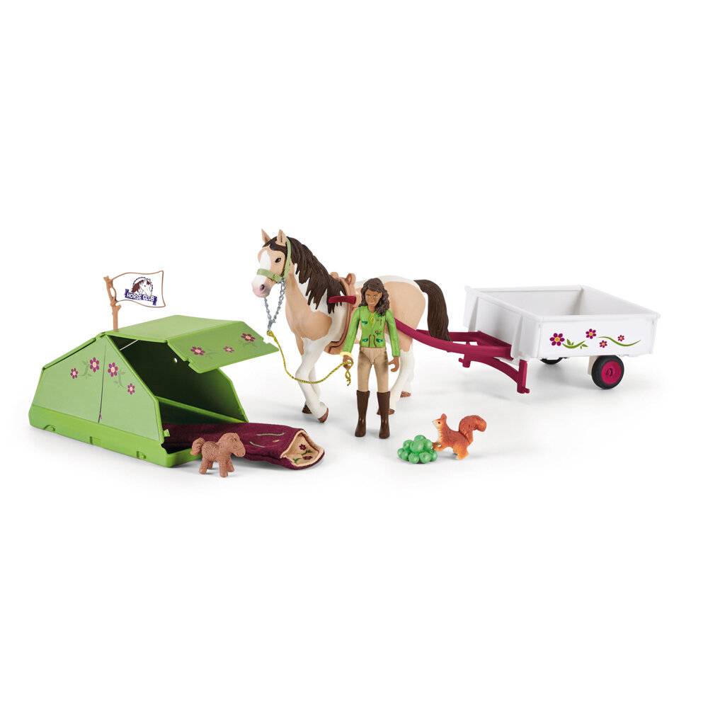 Spielzeug-Campingset mit einem Pferd, einer Reiterfigur, grünem Zelt, Schlafsack und dekoriertem Anhänger auf weißem Hintergrund.