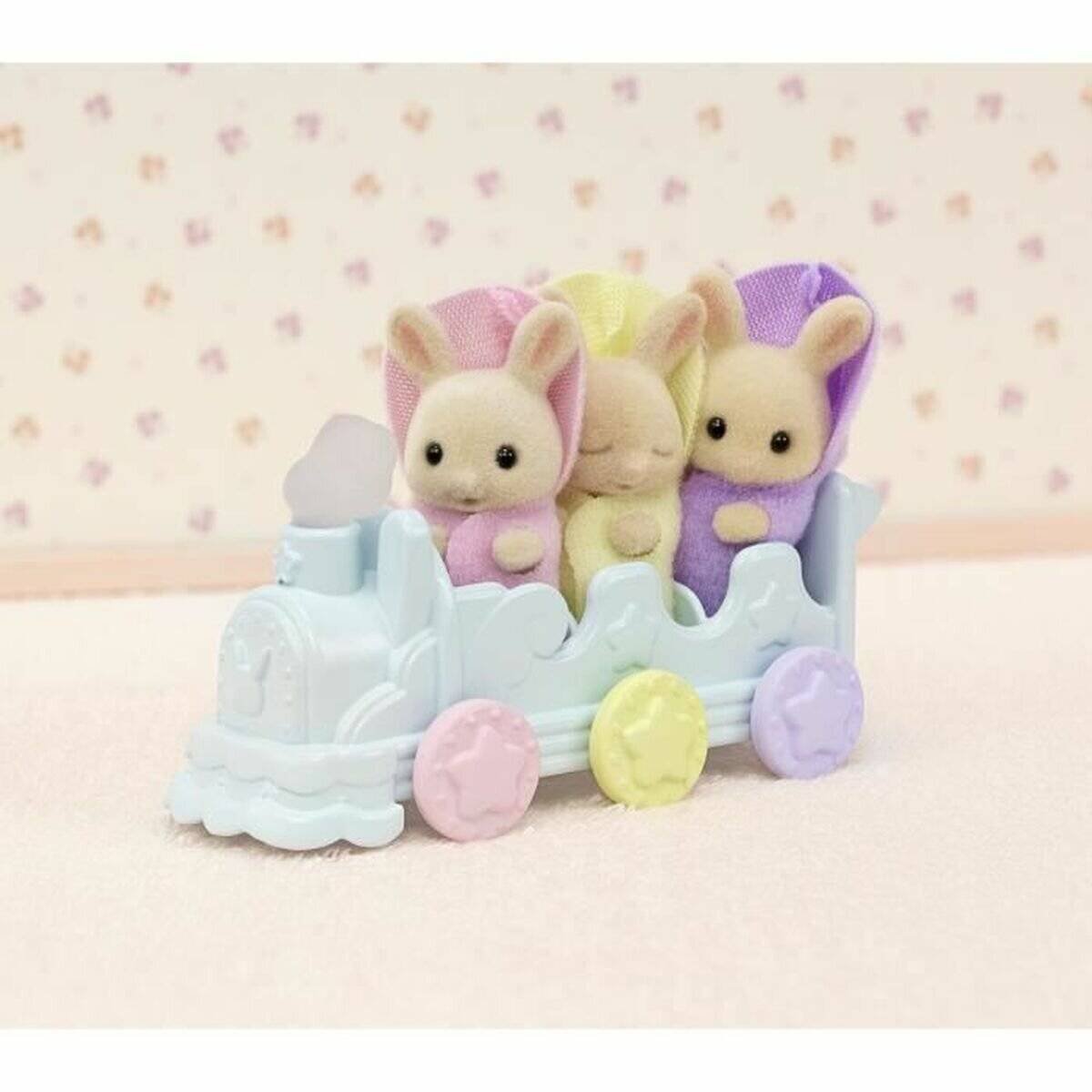 Drei Pastell-Hasen-Figuren fahren in einer hellblauen Spielzeugkutsche mit rosa, gelben und violetten Rädern.