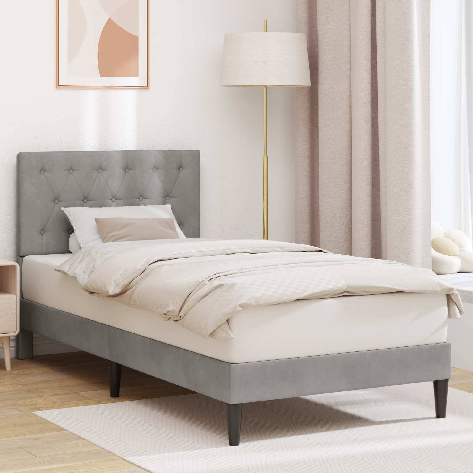 Grau gepolstertes Bett mit gestepptem Kopfteil in einem hellen Schlafzimmer, ausgestattet mit weißer Bettwäsche, neben einer Stehlampe und Vorhängen.