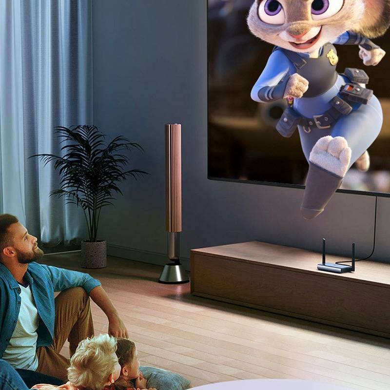 Ein Mann und zwei Kinder sitzen auf dem Boden und schauen auf einen großen Fernseher, der in einem Wohnzimmer einen animierten Polizeihasen zeigt.