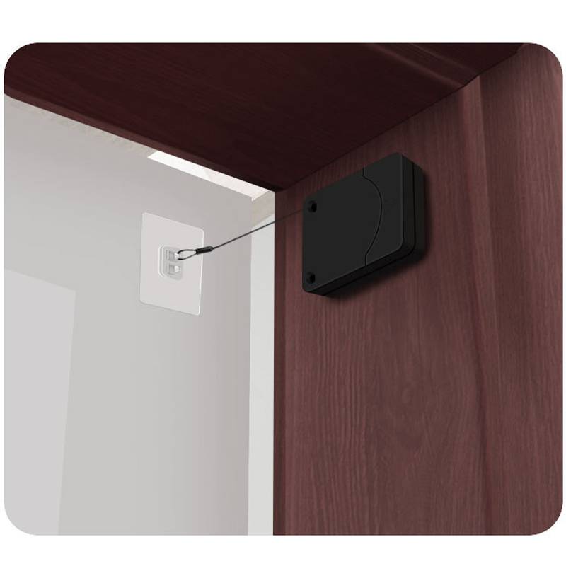 Schwarze wandmontierte Kabelabdeckung verbirgt ein Kabel, das zu einer Wandsteckdose neben einer Holzschrankeinrichtung führt.
