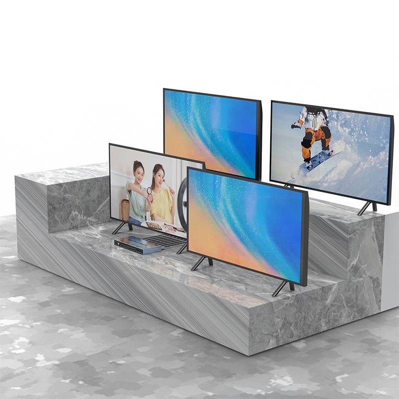 Vier Flachbildschirm-Fernseher, die auf einer gestuften marmorähnlichen Plattform angebracht sind und farbenfrohe abstrakte Bildschirme, eine Frau mit einem Kind und einen Snowboarder zeigen.