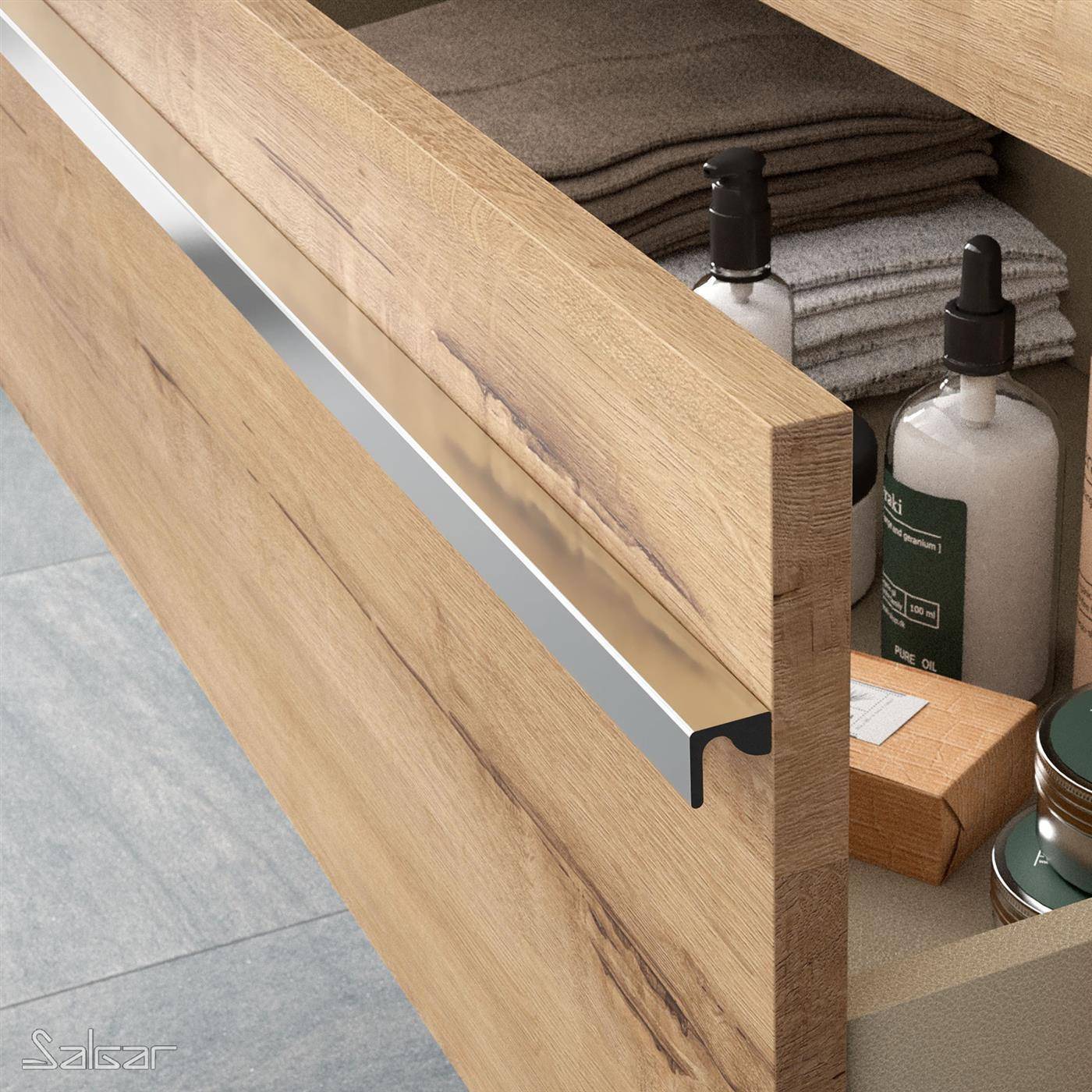 Offene hölzerne Badezimmer-Waschtischschublade mit Metallgriff, die gefaltete Handtücher und Toilettenartikelflaschen im Inneren zeigt.