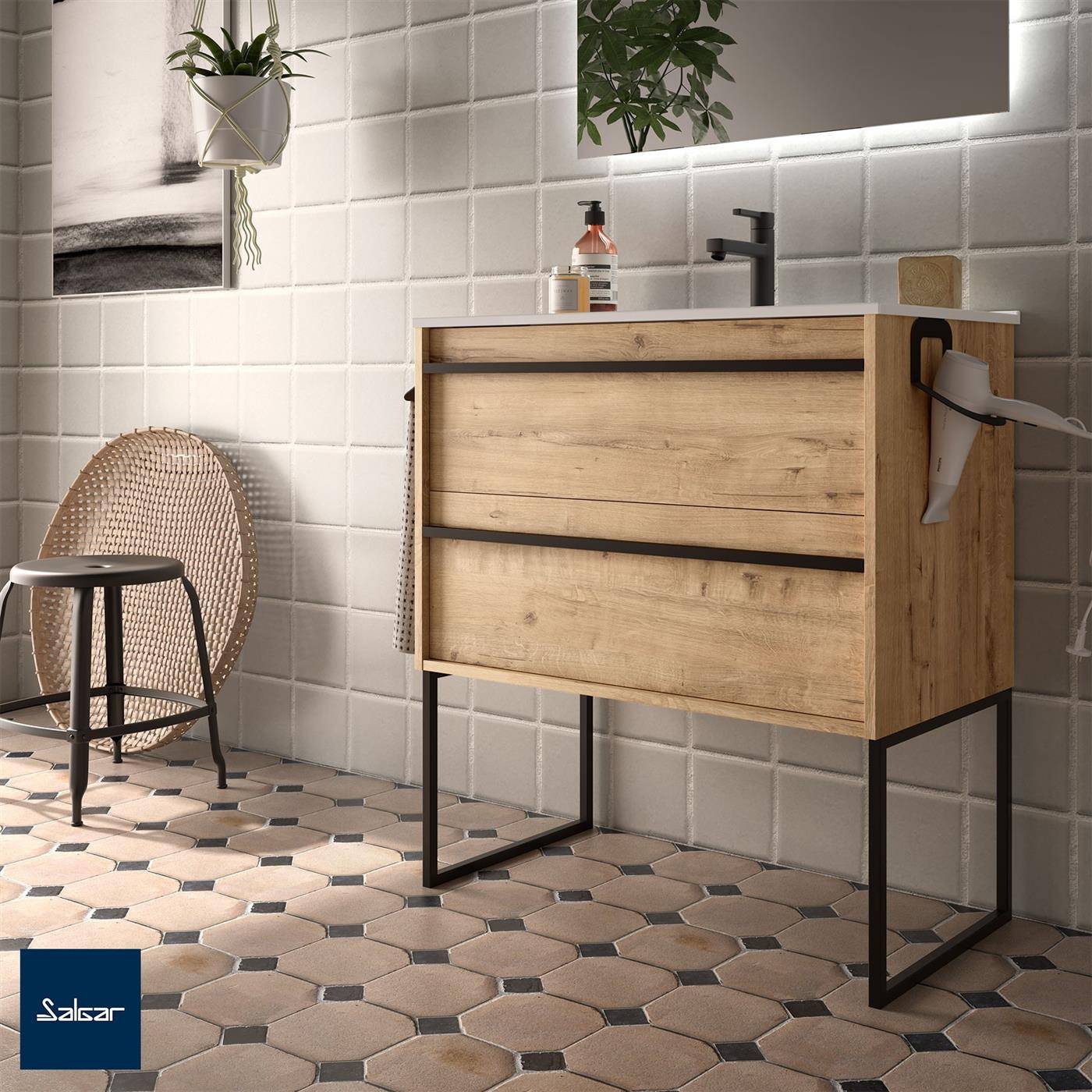 Modernes Badezimmer mit Holzwaschtisch auf schwarzem Metallrahmen, rundem Spiegel, Wandpflanze, Hocker und sechseckigen Fliesen auf dem Boden.