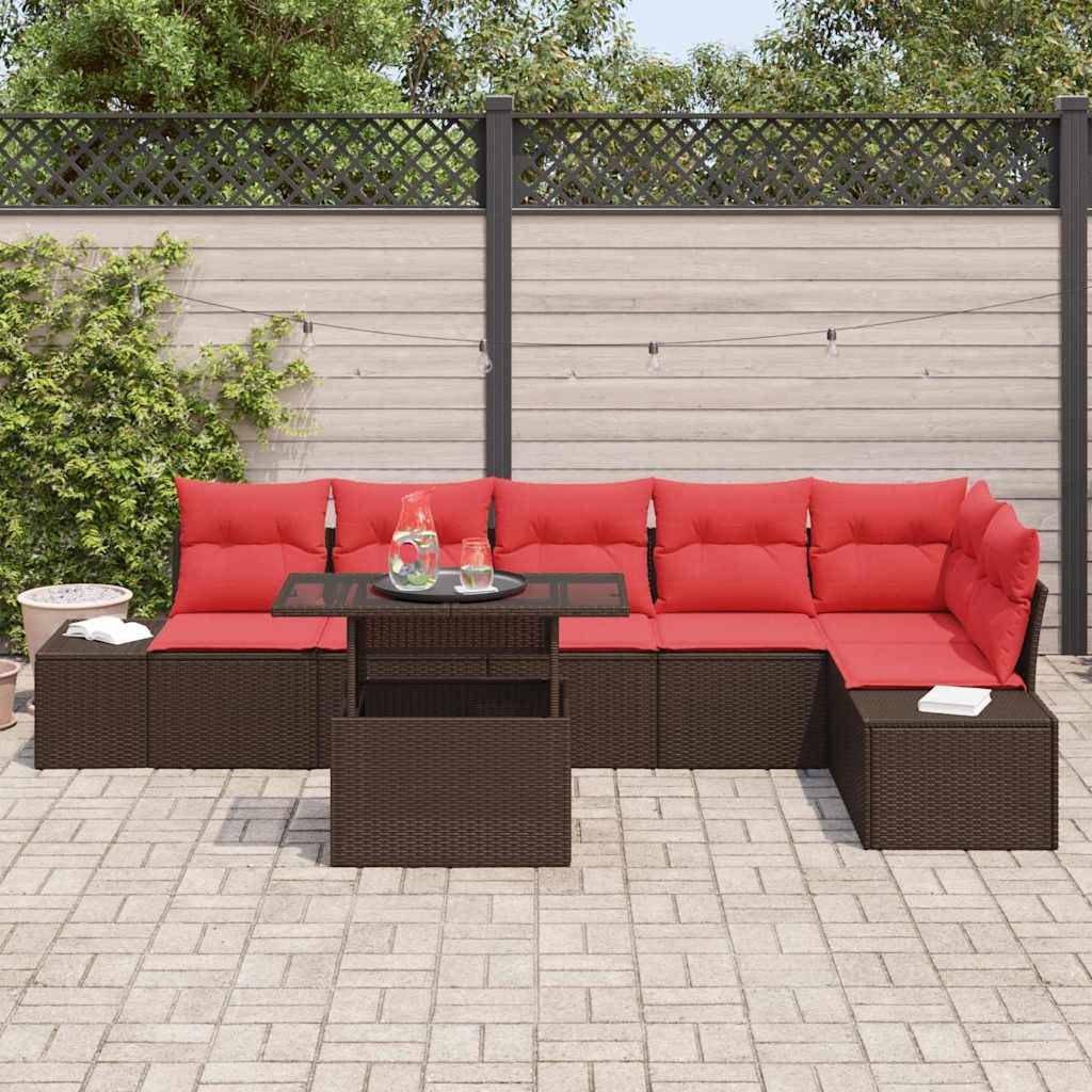 Außenterrasse mit rotem Wicker-Ecksofa mit Kissen und Glaskaffeetisch auf einer gepflasterten Terrasse vor einem Sichtschutz­zaun.