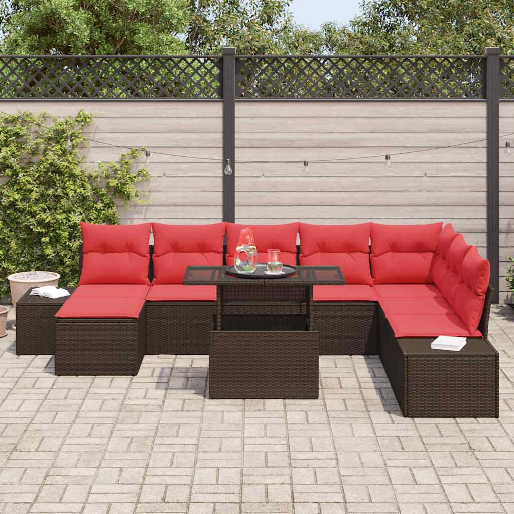 Rote Korbmöbel-Terrasse Eckgarnitur mit roten Kissen, angeordnet um einen Glastisch-Couchtisch auf einer gepflasterten Hinterhof-Terrasse, vor einem Zaun und Grünflächen.