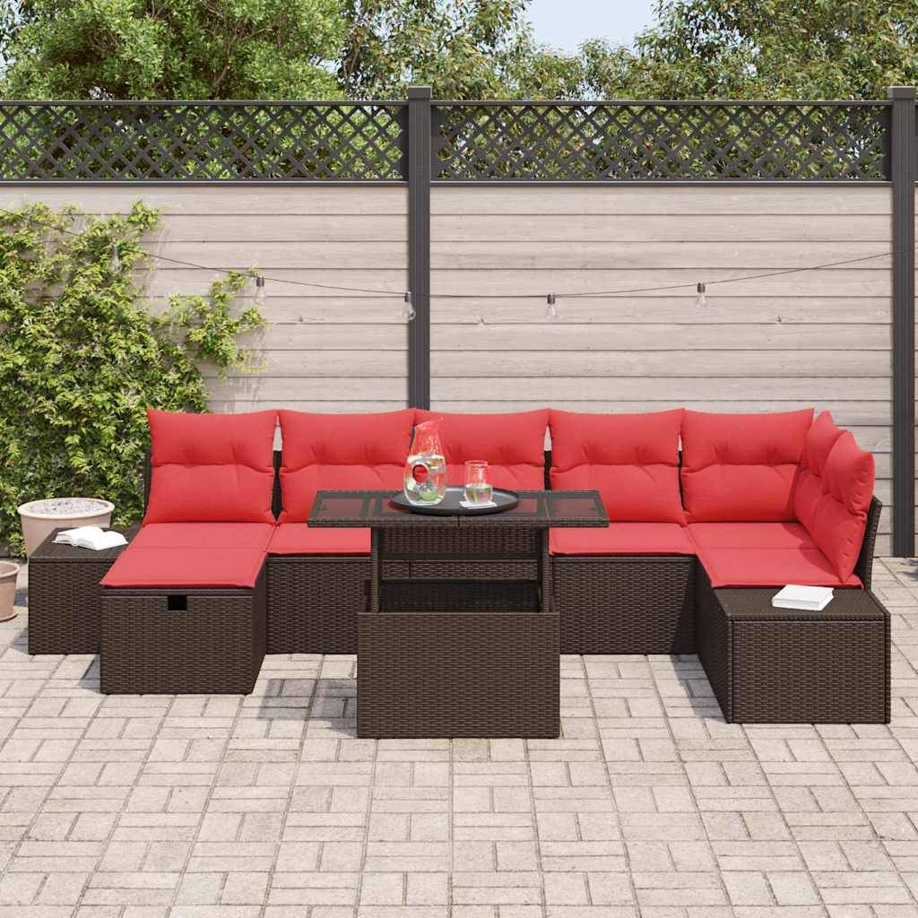 Outdoor-Sitzmöbel-Set mit roter Polsterung und Korbgeflecht-Untergestellen rund um einen Glastisch, vor einem eingezäunten Hof im Hintergrund.
