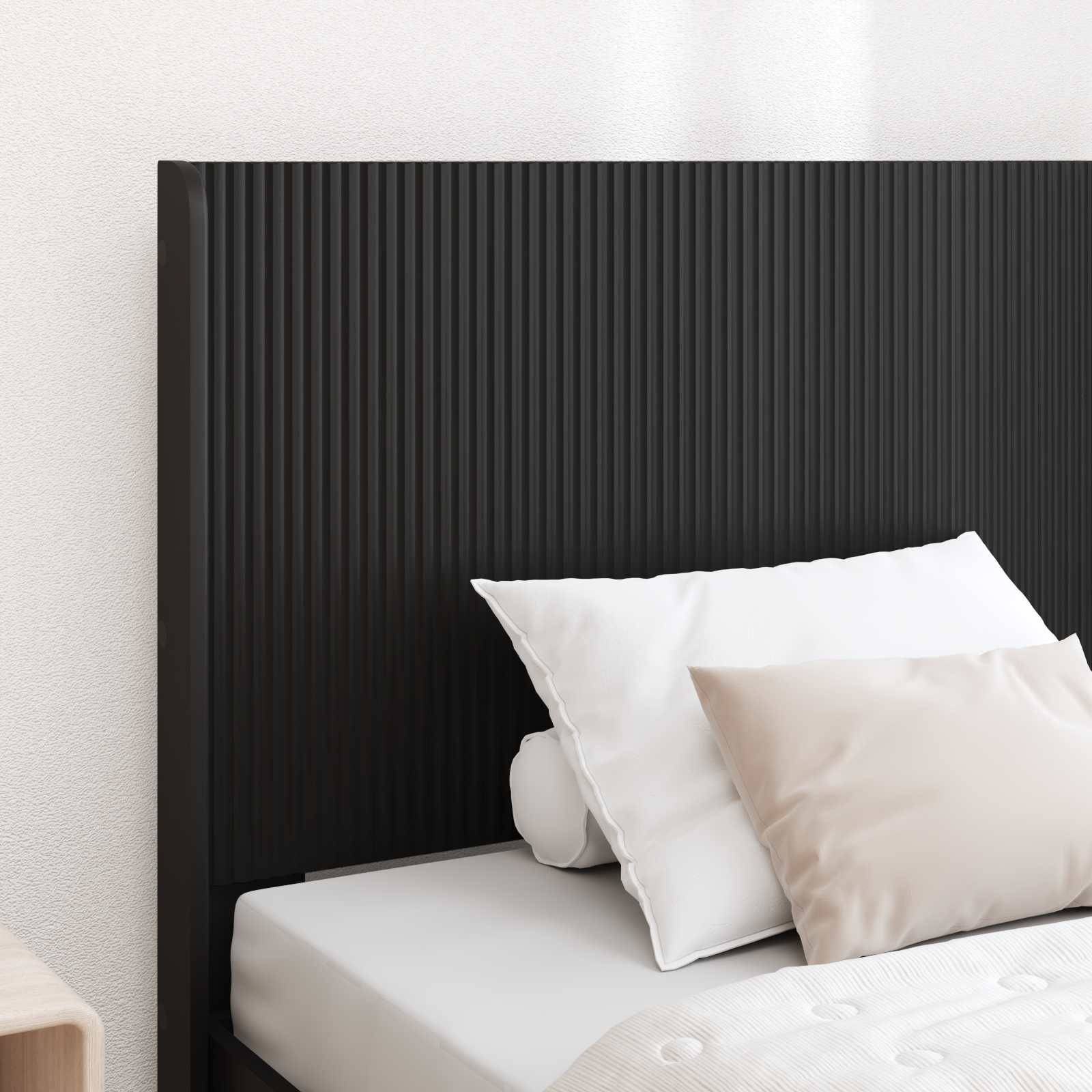 Nahaufnahme eines ordentlich gemachten Bettes mit weißen Kissen und Bettwäsche vor einem schwarzen gerippten Kopfteil in einem minimalistischen Schlafzimmer.