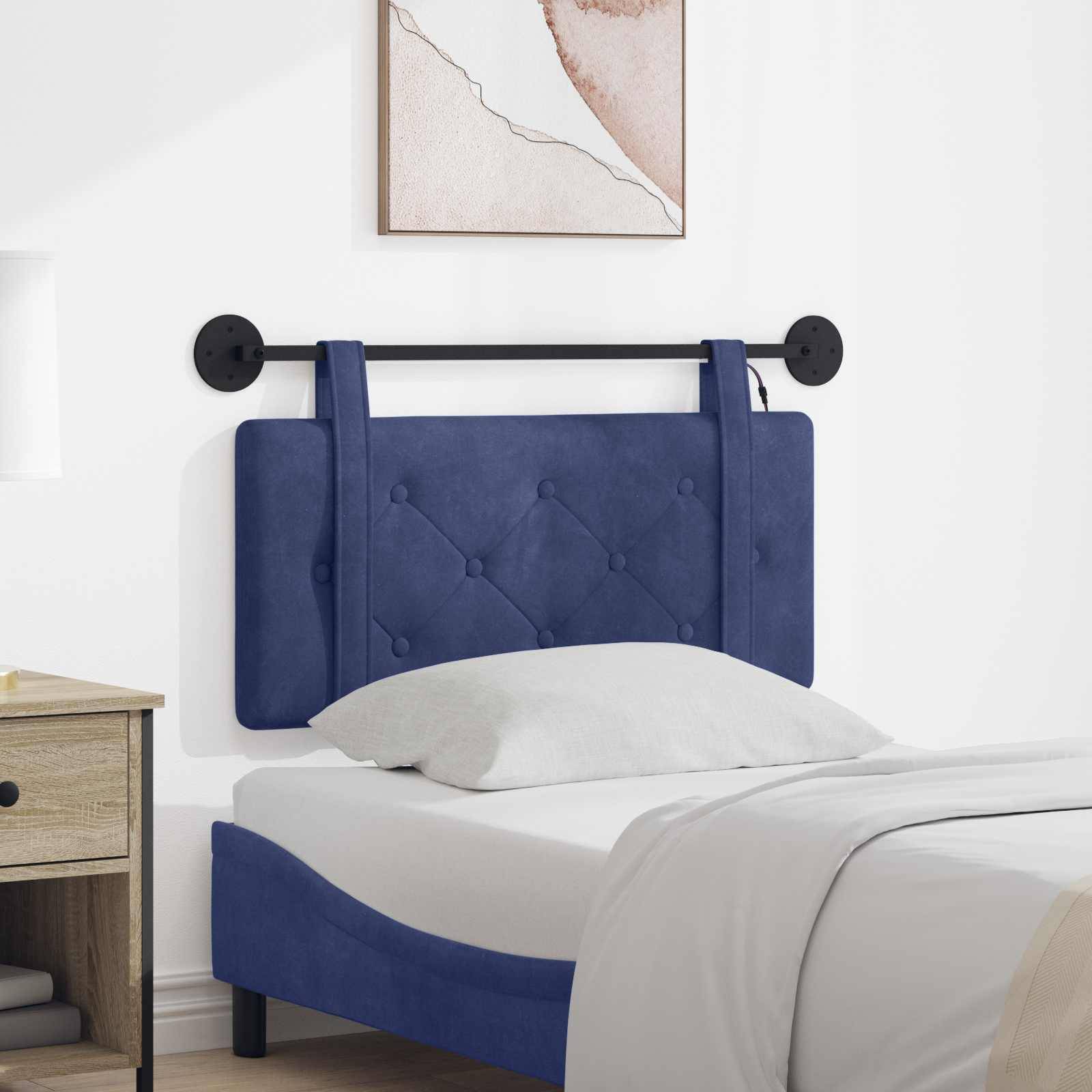 Blaues gepolstertes Bett mit wandmontiertem Kopfteil und schwarzer Schiene in einem weißen Schlafzimmer, ausgestattet mit weißer Bettwäsche und grauem Kissen.