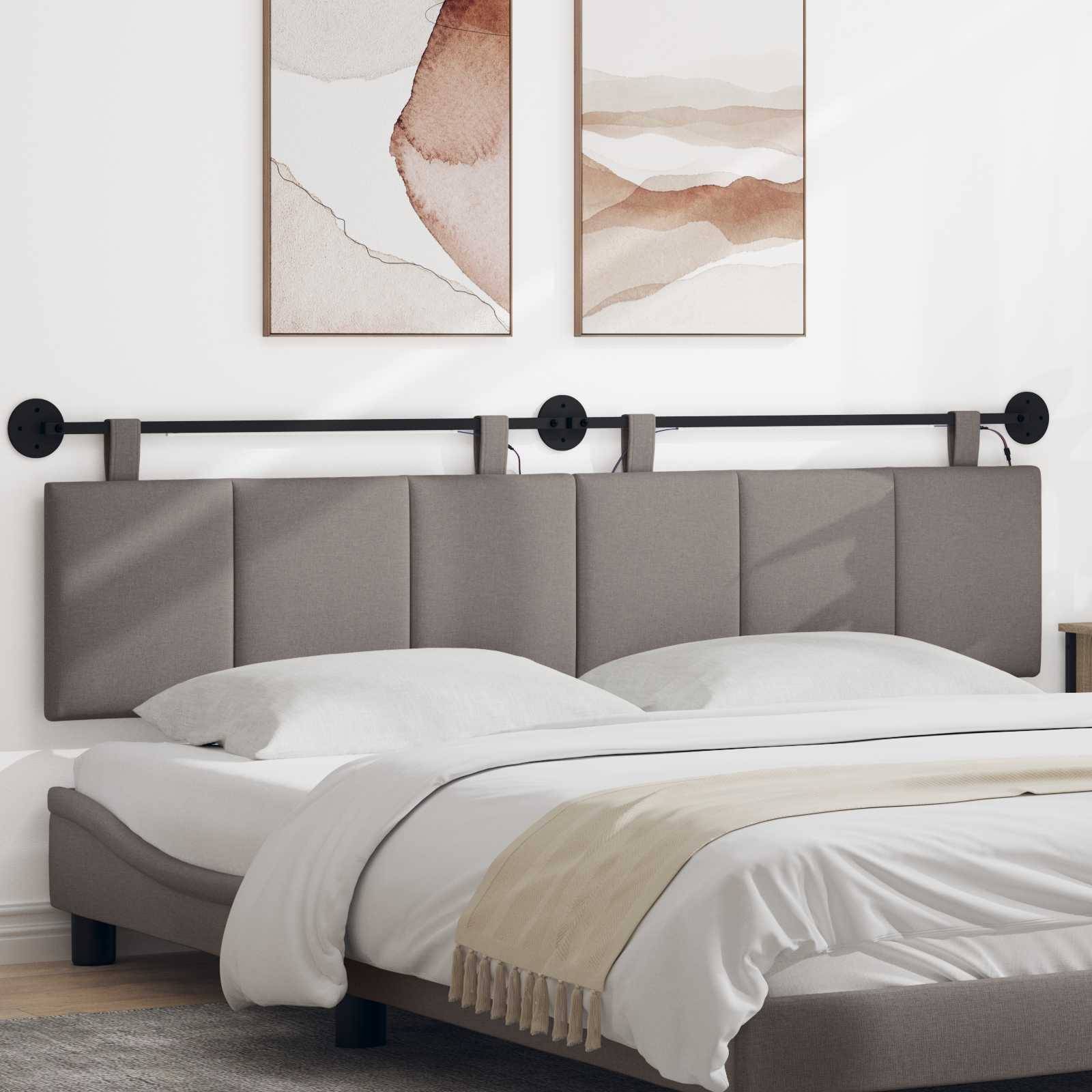 Ein modernes, gepolstertes Bett mit grauem Kopfteil, weißer Bettwäsche und minimalistischer Wandkunst darüber in einem hellen Schlafzimmer.