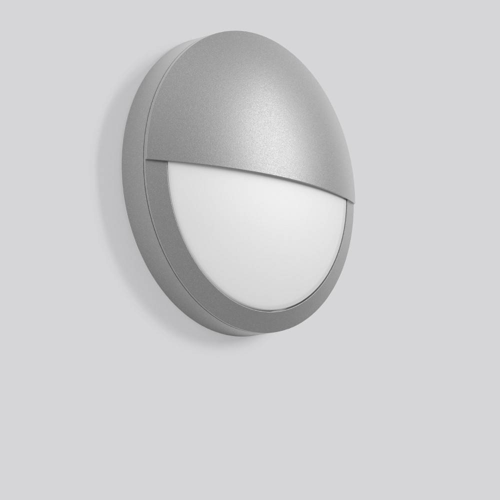 Modernes Wandleuchtenmodul in Grau mit rundem Metallgehäuse und mattweißem Diffusor vor einem einfachen hellgrauen Hintergrund.