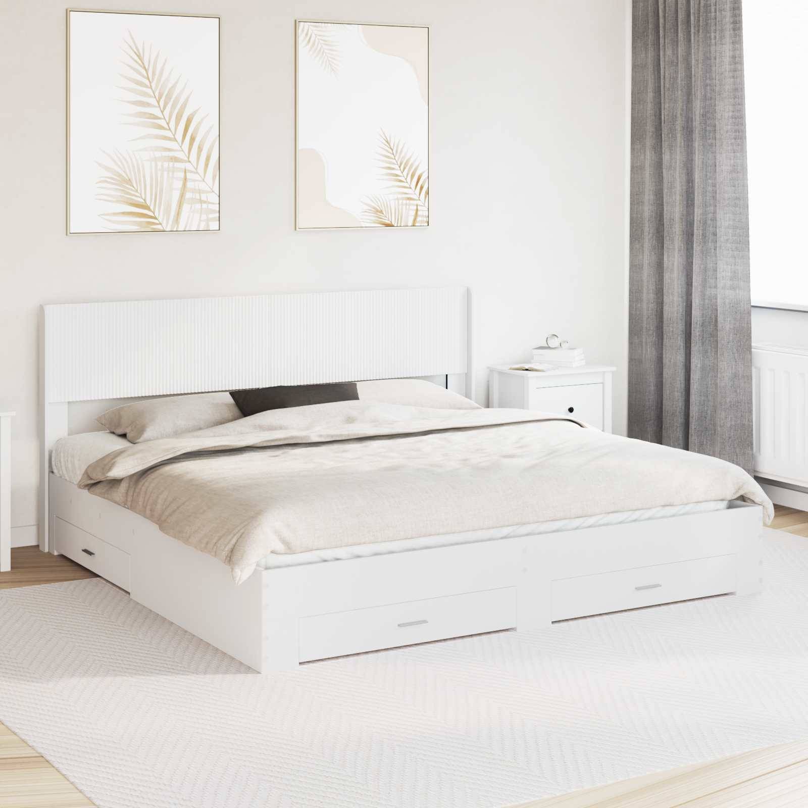 Helles minimalistisches Schlafzimmer mit weißem Stauraumbett, beigefarbener Bettwäsche, gerahmter Blatt-Wandkunst, Nachttisch und grauen Vorhängen.