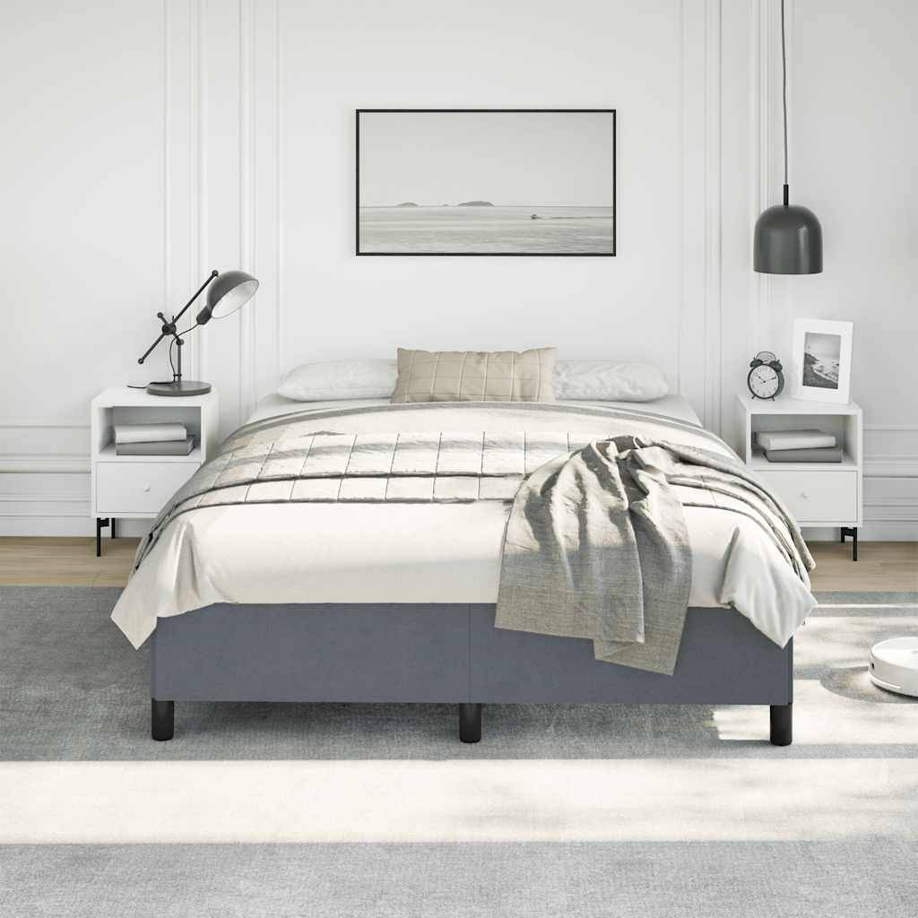 Minimalistisches Schlafzimmer mit grauem Bett, weißen Nachttischen und Lampen, gerahmter Meereslandschaft über dem Kopfteil und einer drapierten Decke auf dem Bett.