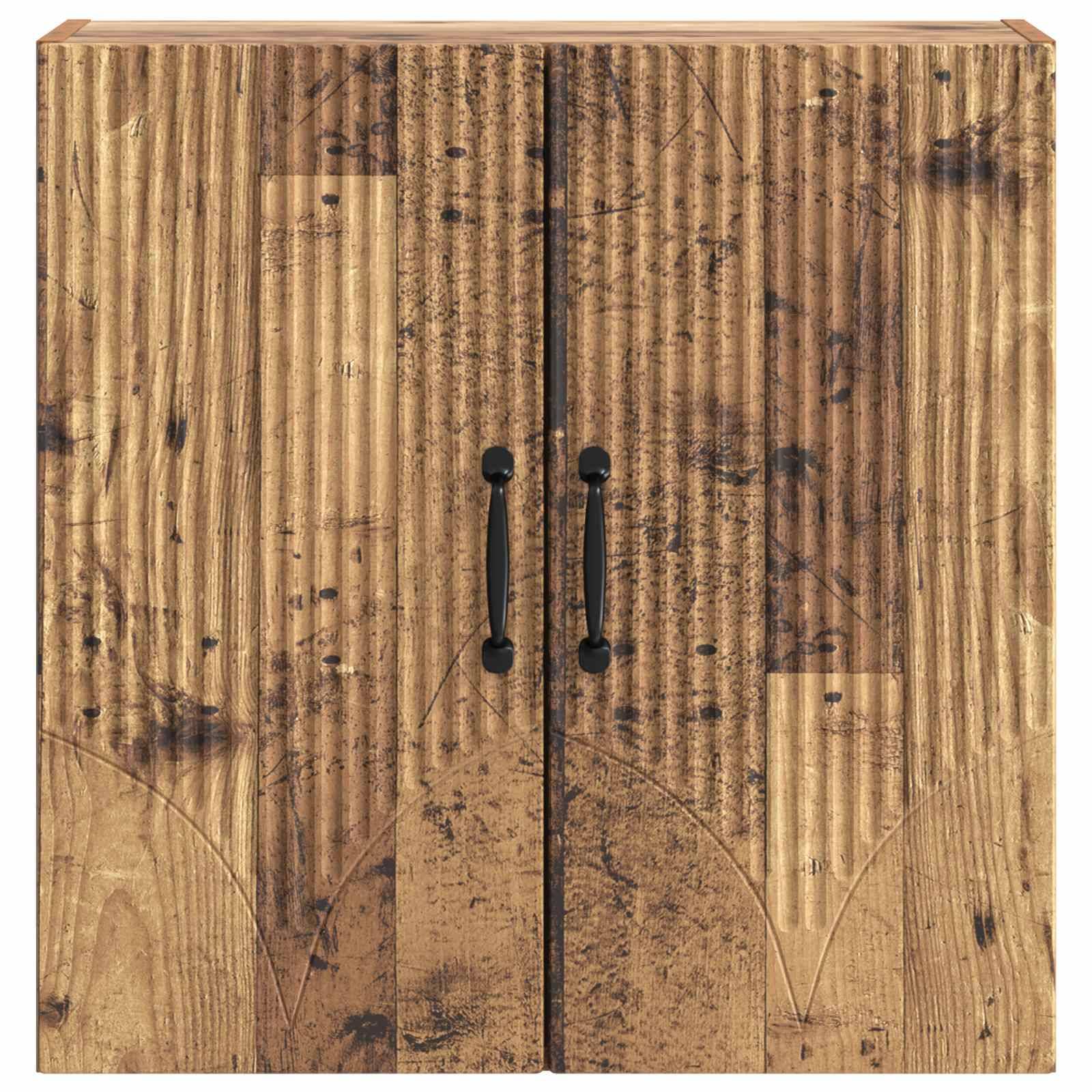 Holzschrank mit zwei schwarzen senkrechten Griffen an geschnitzten, verwitterten Türen.