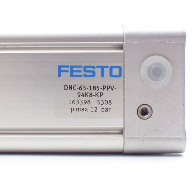 Nahaufnahme einer Festo-Pneumatikzylinder-Endkappe mit einer Beschriftung, die das Modell „DNC-63-185-PPV-94K8-KP", die Teilenummer 163398 und den maximalen Druck von 12 bar zeigt.