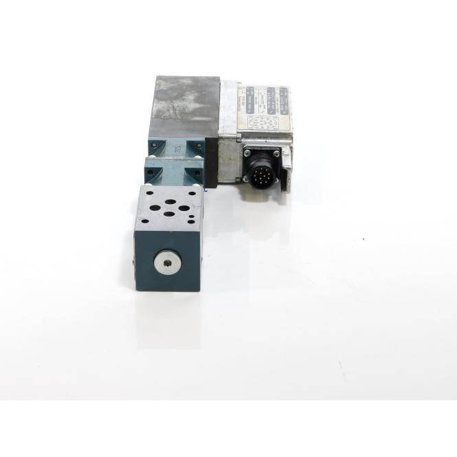 Industrielle Metallventilverteiler mit einem runden elektrischen Stecker, dargestellt auf einfachem weißem Hintergrund.