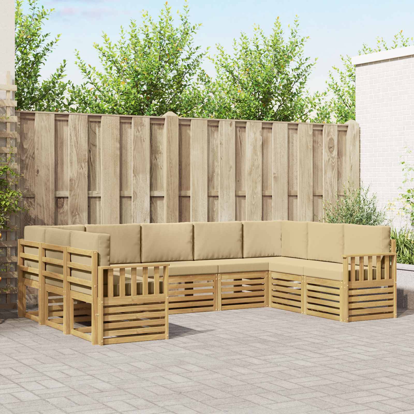 Outdoor-Holz-Modulsofa in L-Form mit beigen Kissen auf einer Terrasse neben einem Holzzaun und Bäumen.