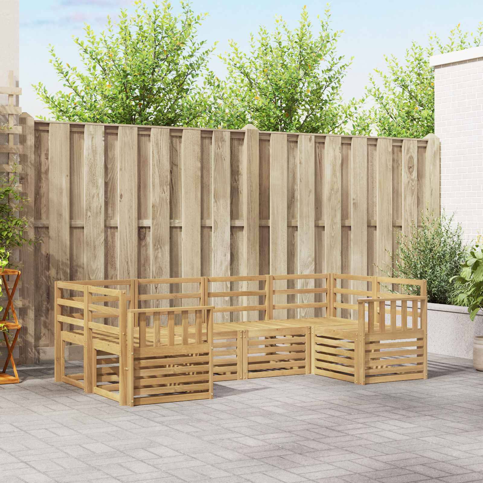 Modulare Gartensitzgarnitur aus Holz mit niedrigen lamellenverstrebten Bänken, die in einer U-Form gegen einen Zaun angeordnet sind