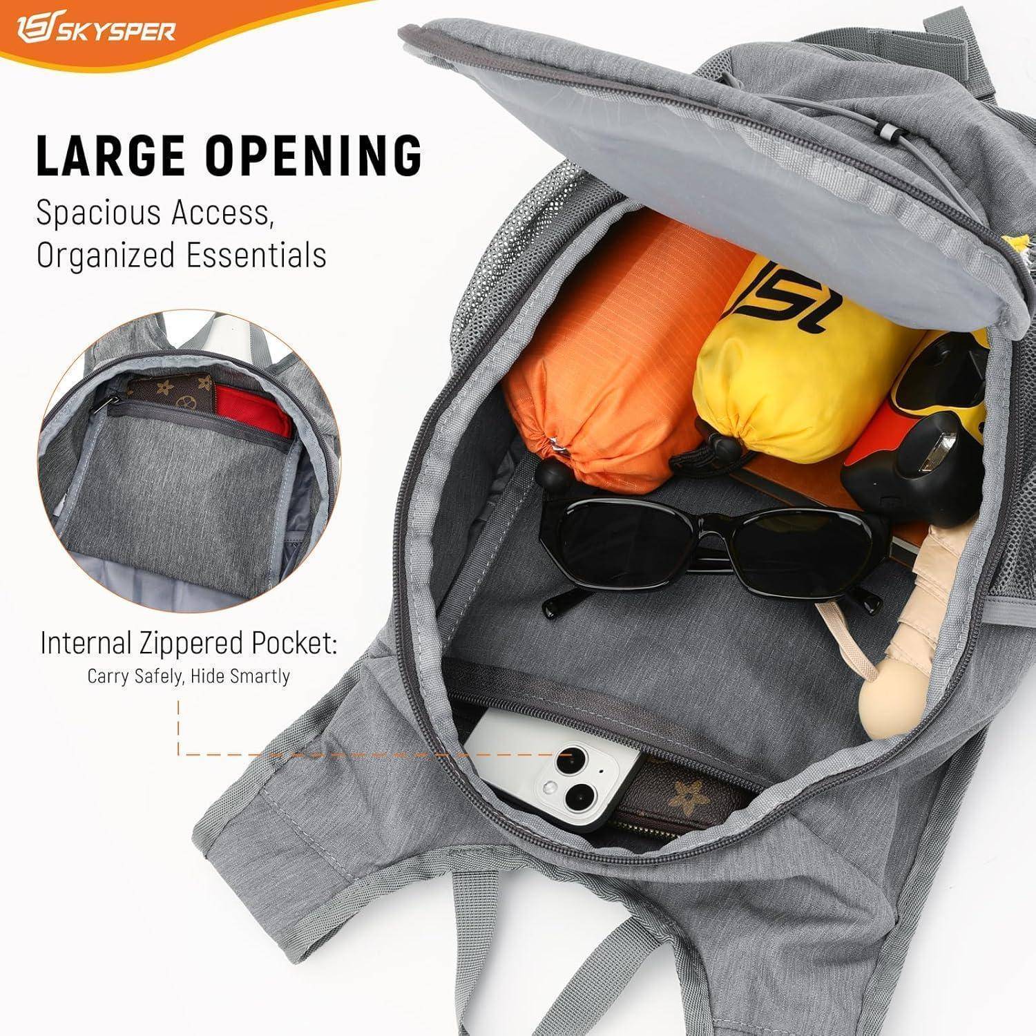 Grauer Rucksack, geöffnet dargestellt, zeigt ein geräumiges Hauptfach und eine innere Reißverschlusstasche mit gepackten Essentials.
