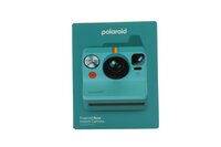 Teal-farbene Polaroid-Sofortbildkamera-Packung auf weißem Hintergrund, mit der Kamera zentriert auf der Schachtel.
