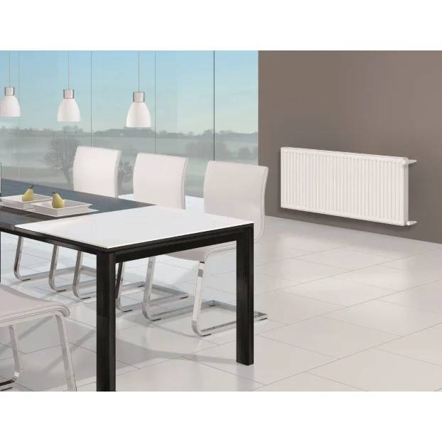 Modernes Esszimmer mit weißen Stühlen um einen Tisch mit schwarzem Rahmen, großen Fenstern, Pendelleuchten und einem an der Wand montierten Heizkörper auf der rechten Seite.