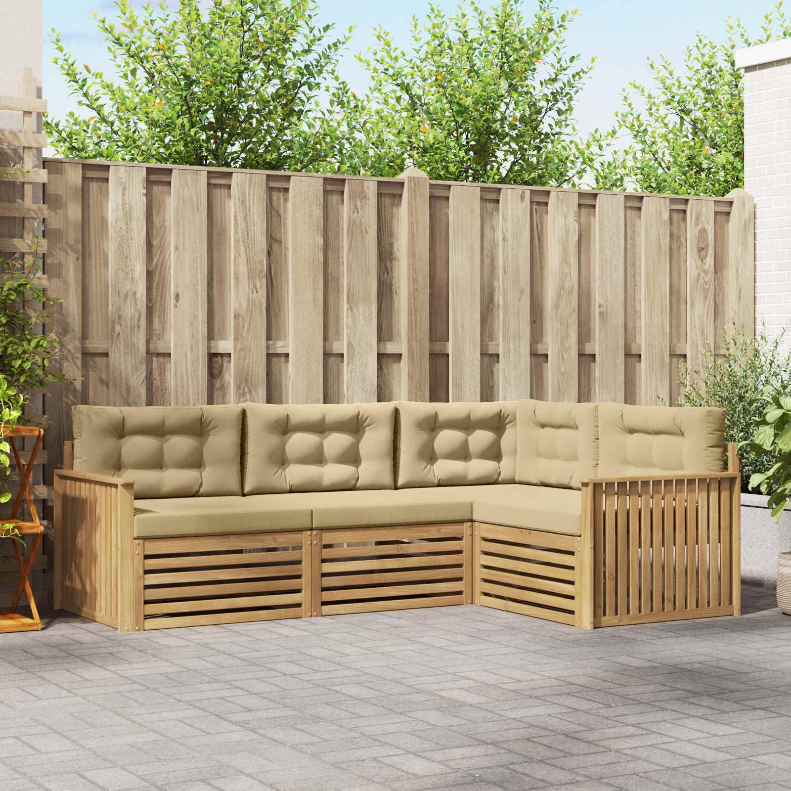 Outdoor L-förmiges Holz-Patio-Ecksofa mit beige gepolsterten Sitzflächen an einem Sichtschutzzaun in einem gepflasterten Hinterhof.