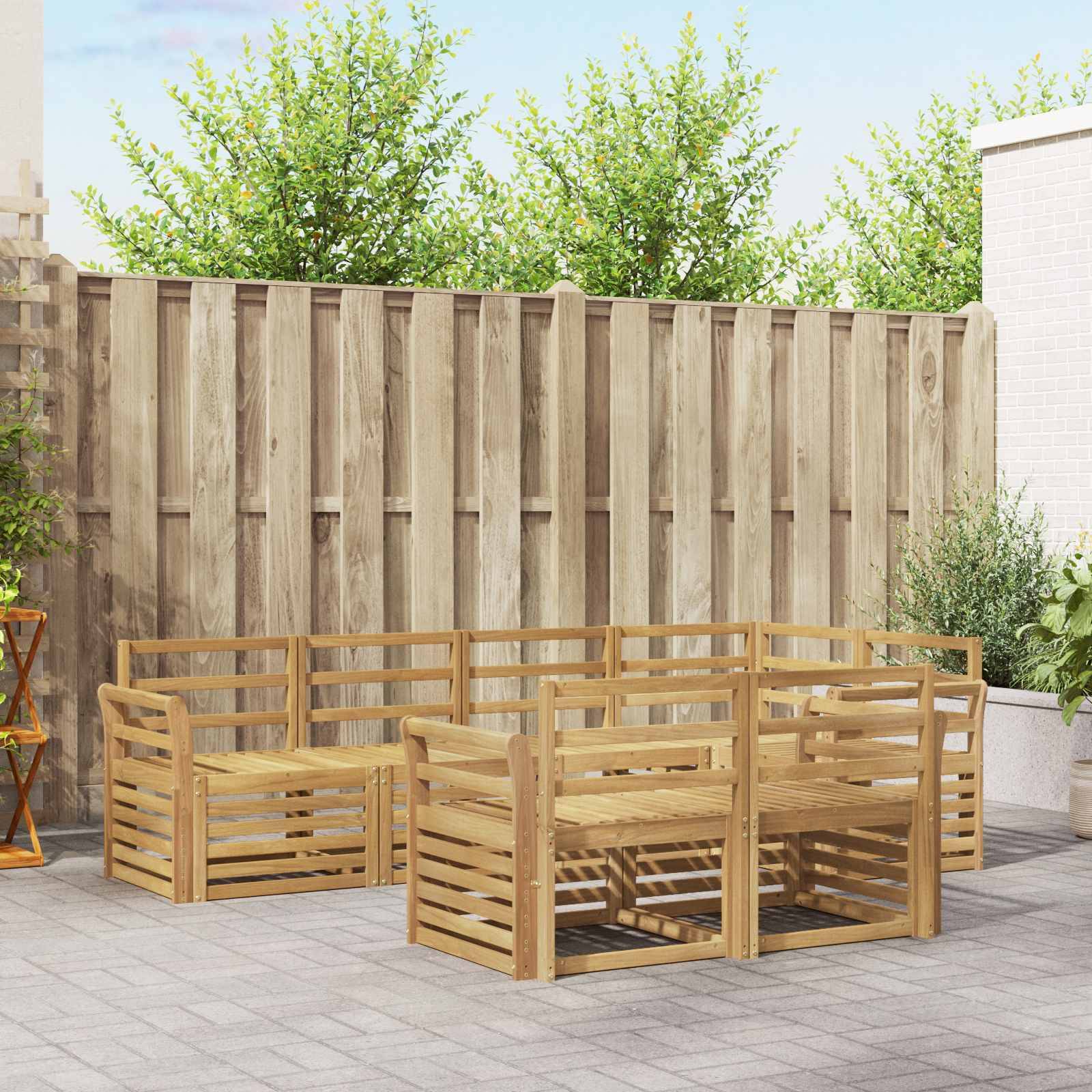 Holzmöbel-Sitzgruppe für den Außenbereich, die quadratisch um einen zentralen Tisch auf einer gepflasterten Terrasse im Hinterhof neben einem Zaun angeordnet ist.