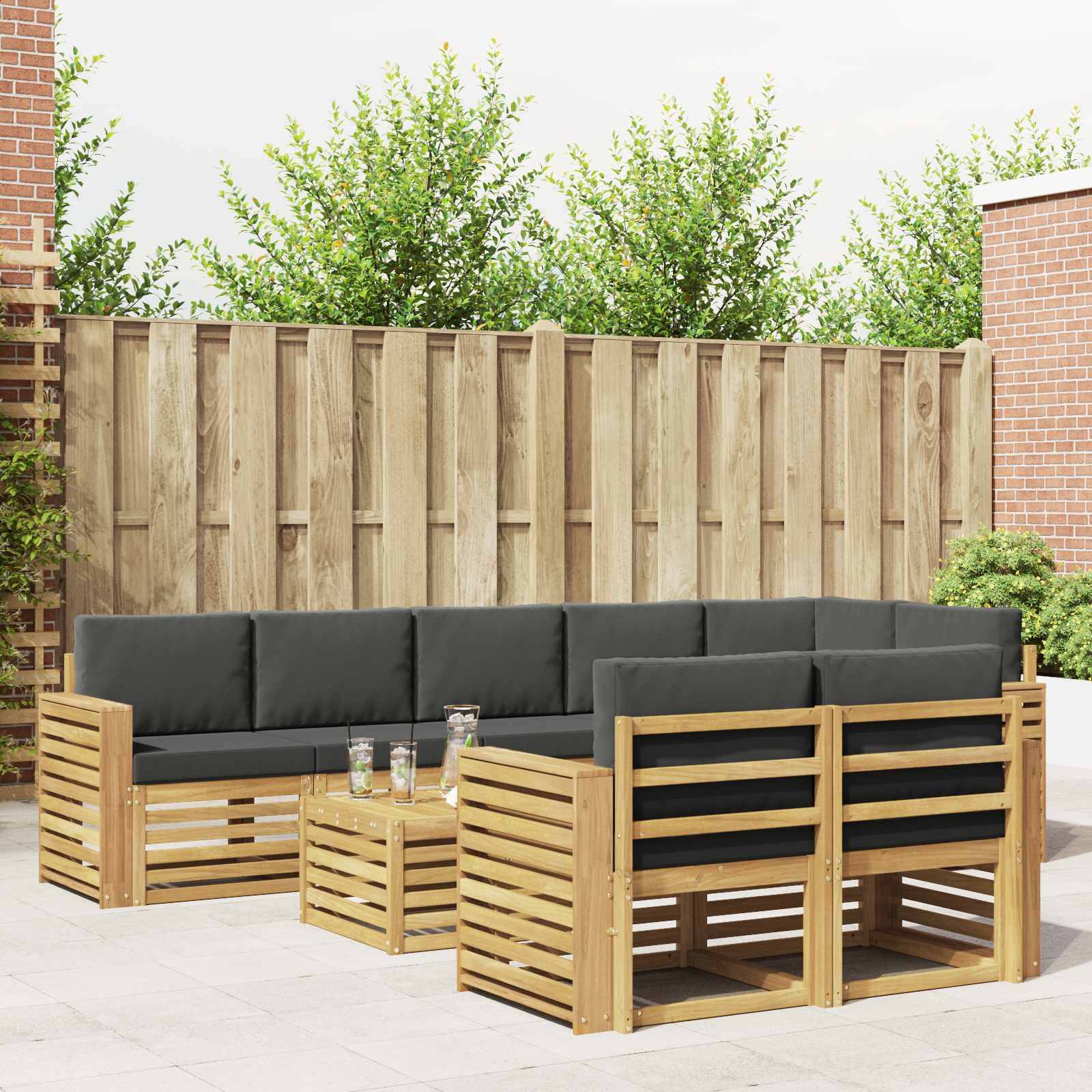 Außenbereich-Terrassenmöbelset mit schwarzgepolsterten Holzsektionalsofas und passendem Lattenrost-Couchtisch in einem umzäunten Hinterhof.