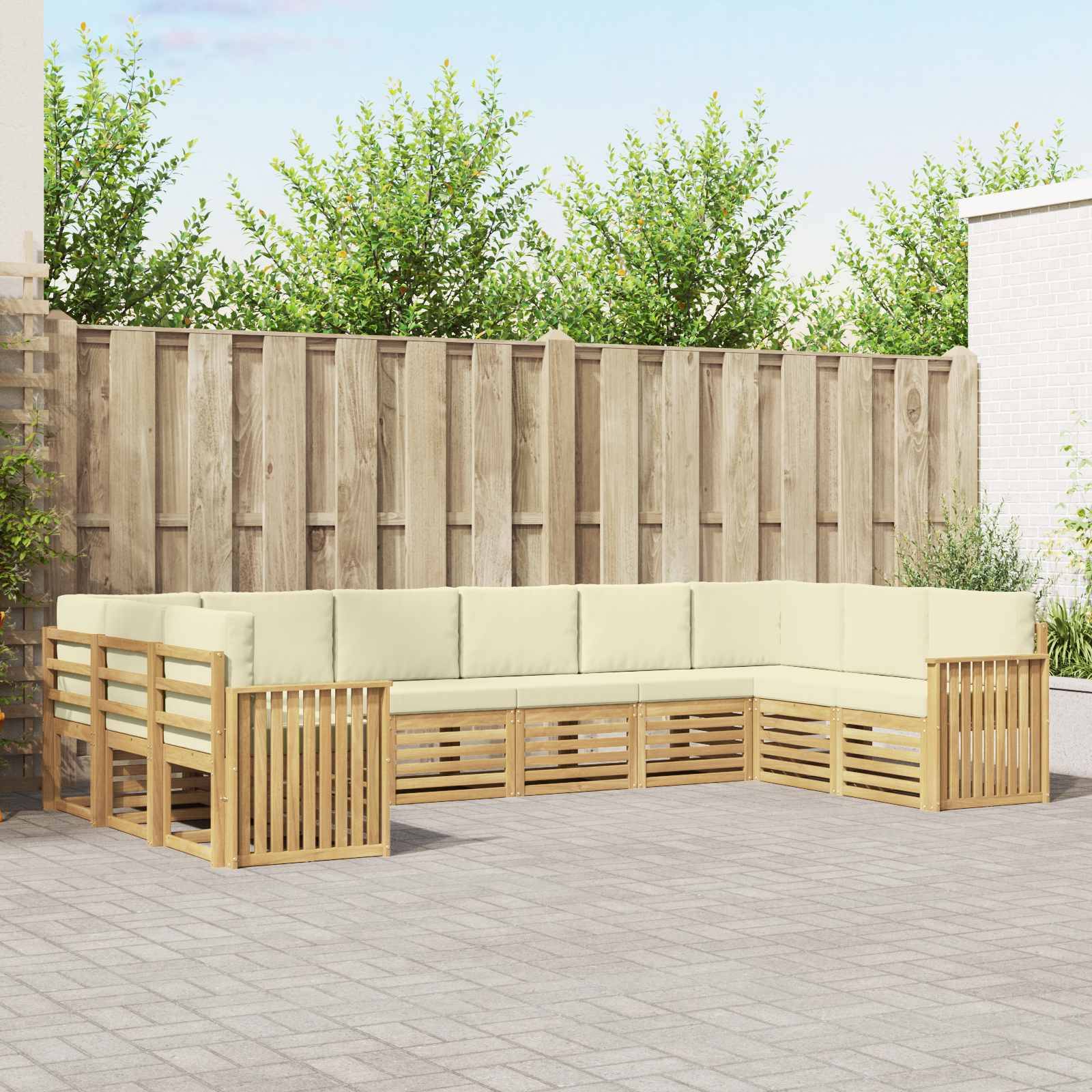 Außen-L-förmiges Holz-Ecksofa mit cremefarbenen Kissen auf einer gepflasterten Terrasse neben einem Holzzaun
