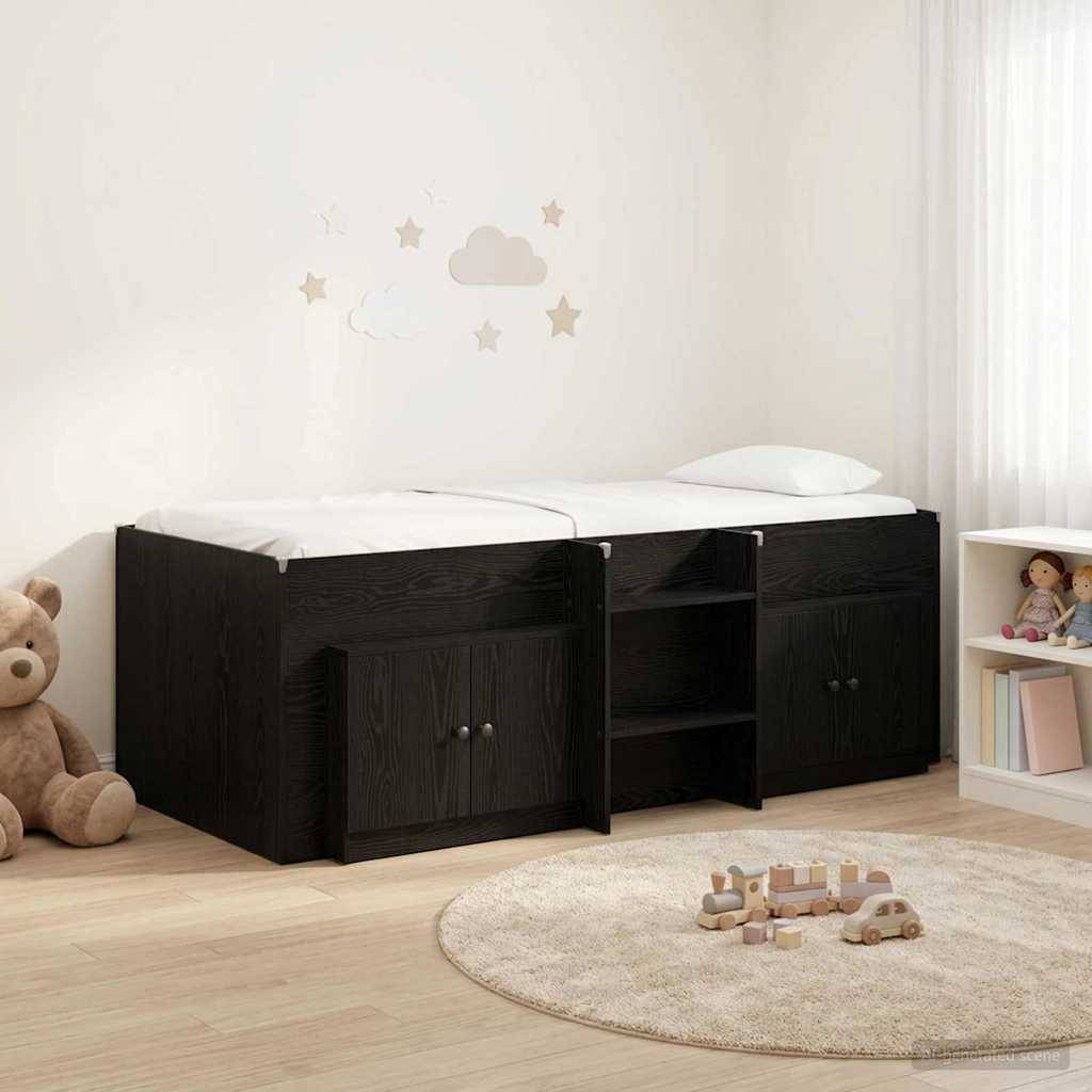 Kinderzimmer mit einem schwarzen Stauraumbett und weißer Matratze, einem Teddybär, einem Spielzeugbrett, einem Teppich und kleinen Spielzeugen auf dem Boden.